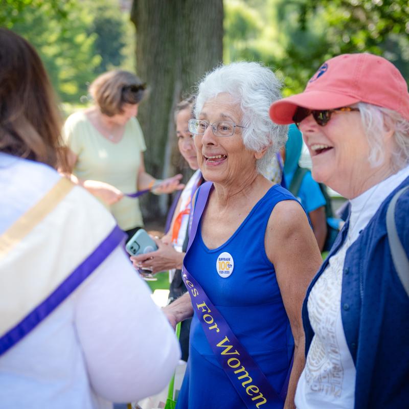 Two women stand outside smiling.
