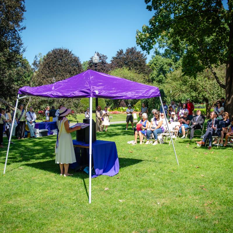 Purple tent and crowd sit outside at Boston Public Garden.