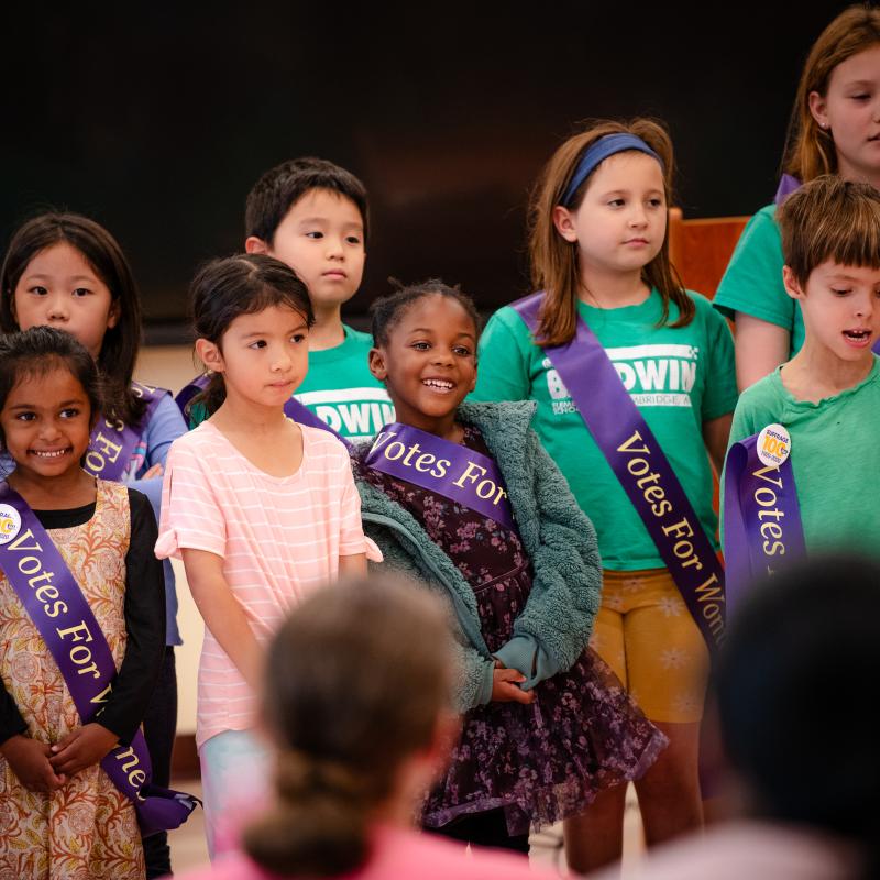 Group of children stand singing.