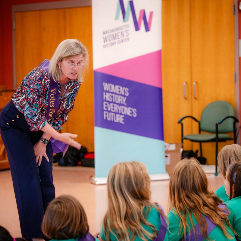 Woman speaking to children.