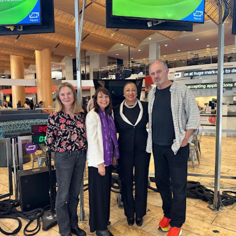 4 people standing together and smiling in a radio studio