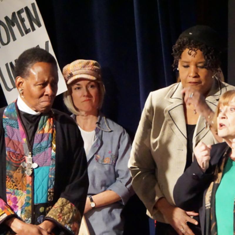 Four women stand on stage.