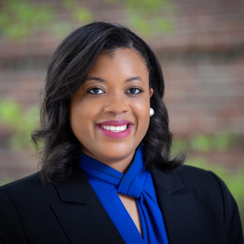 Headshot Dr. Alexandria Russell, posing for the camera and smiling, wearing a bright blue scarf.