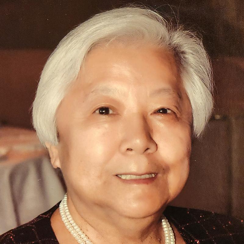 Woman (Caroline Chang) smiles at camera.