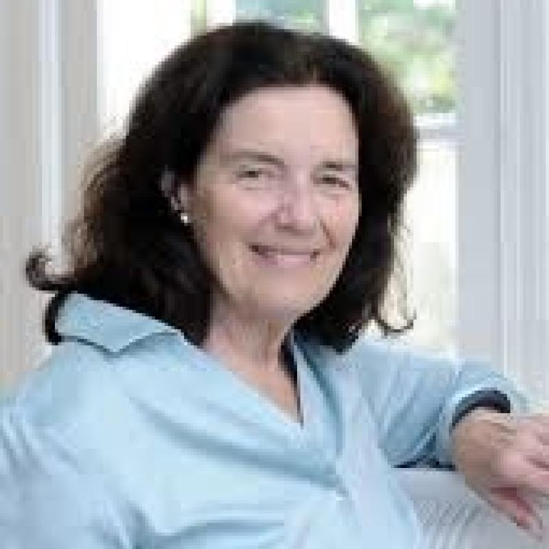 A woman standing in front of a window and smiling.