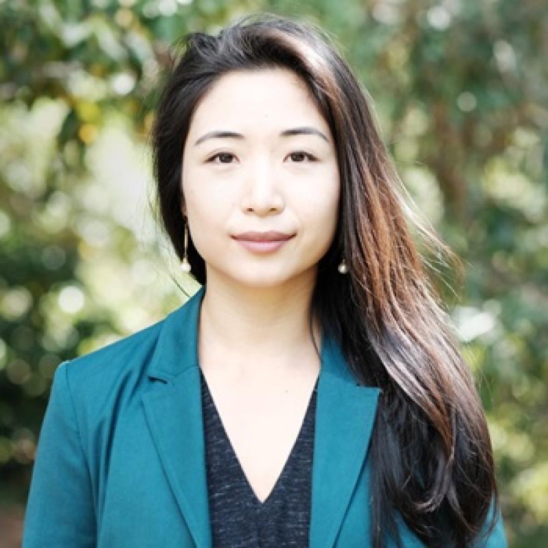 headshot of a standing outside woman wearing a green jacket