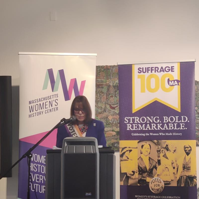 Woman speaking at podium.