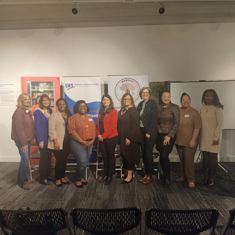 10 women stand in group smiling.