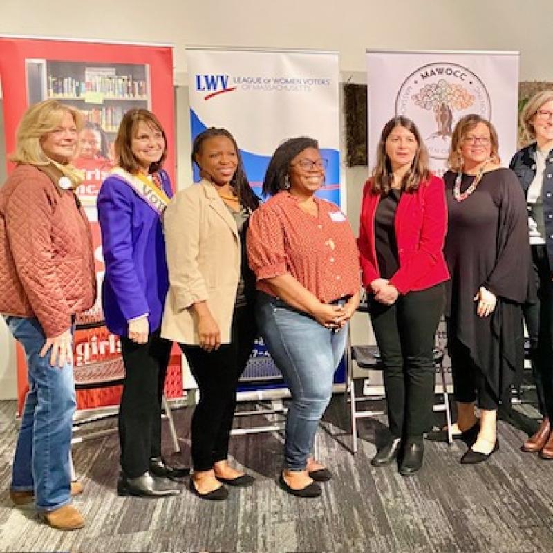 10 women stand in group smiling.