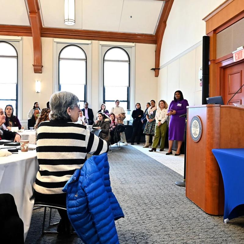 Woman stands at podium speaking.