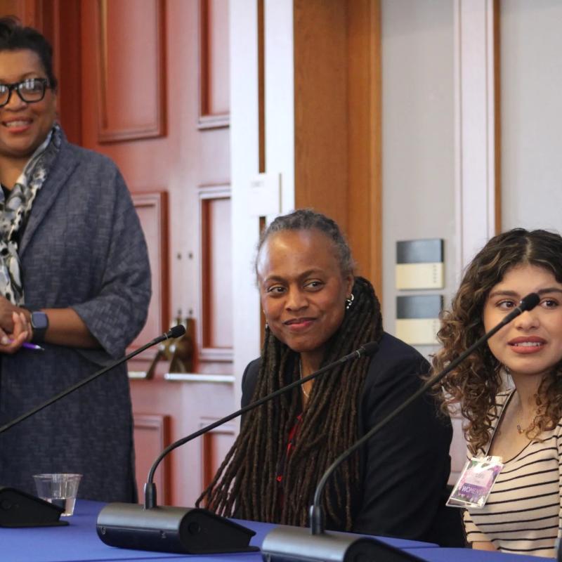 Two women sit at microphones.
