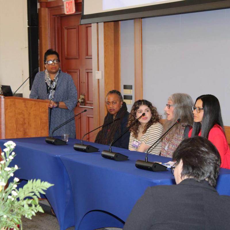 Four women sit at microphones.