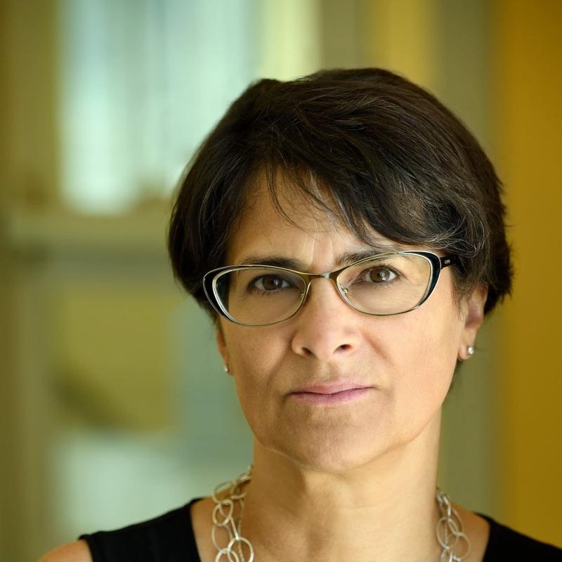 Woman in glasses smiles.