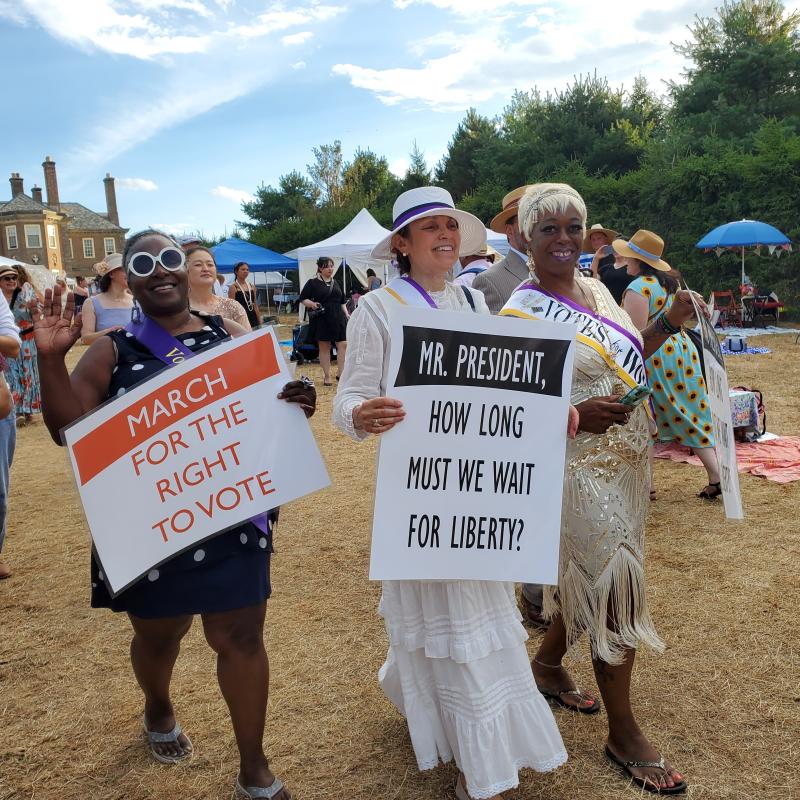 Three women march in parade.