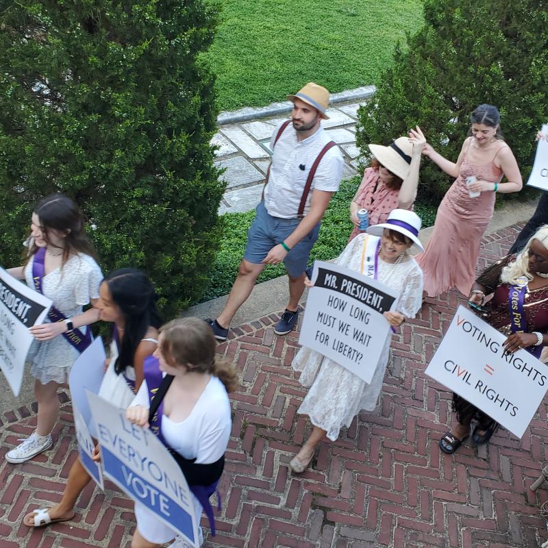 Parade marches down brick path.