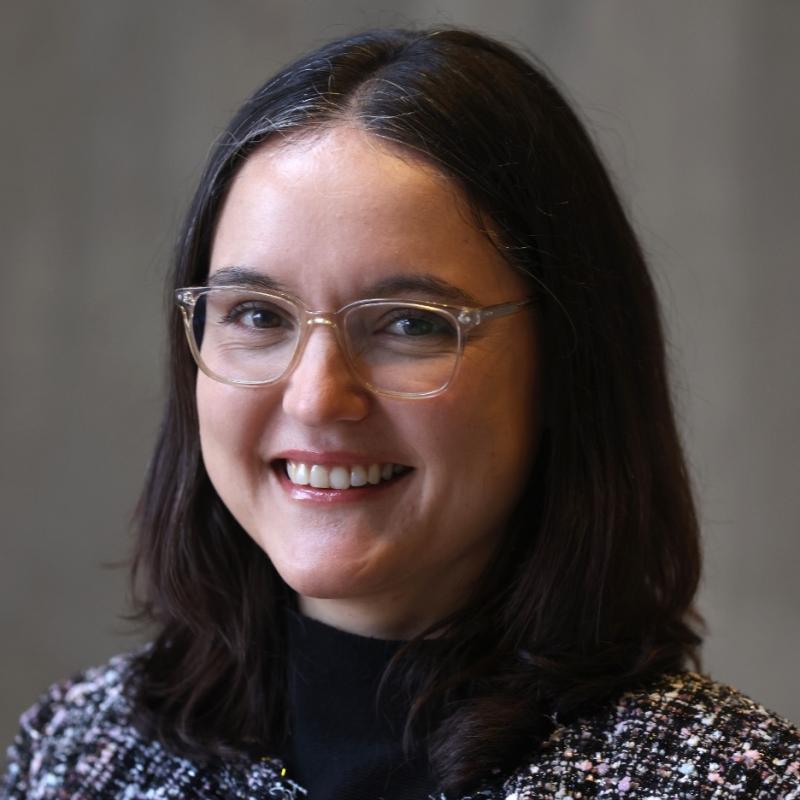 Headshot of woman wearing glasses smiling.