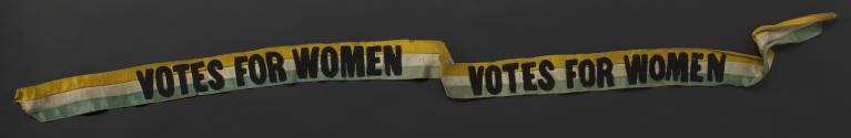 Green, white and gold striped satin sash, with 'Votes for Women' twice in black felt letters