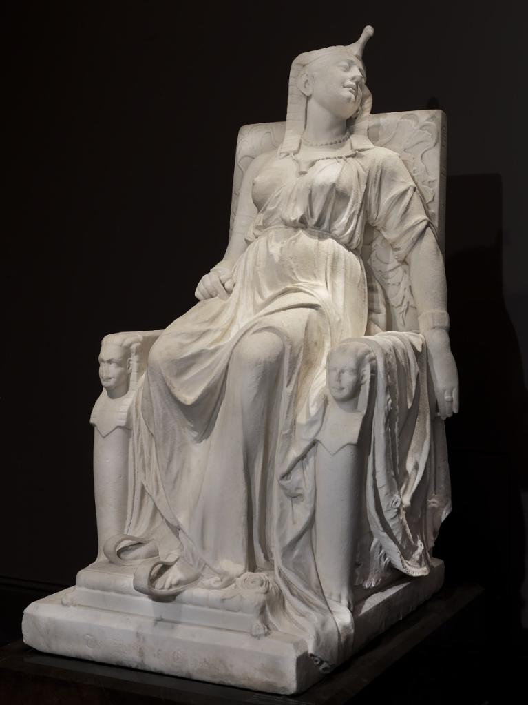 Marble sculpture of Cleopatra, the queen of Egypt, on her throne at the moment of her death, clad in regal attire.